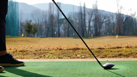 Golfer Training Golf Swing with 3 Wood in Driving Range on Mat in a Sunny Day Stockbeeldmateriaal 194012135