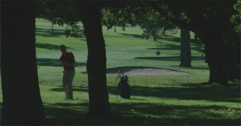 Golfer in the trees hit's out of the rough towards camera. 스톡 동영상 58850971