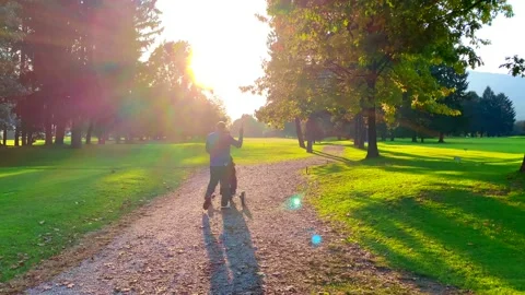 Golfer Walking on the Golf Course with His Golf Push Cart in Sunset Stock Footage 163950798