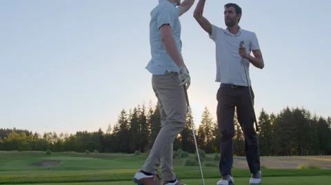 Golfers high five after their tee shot Stock Footage 61002010