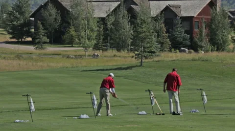 Golfers practice at a golf course driving range in Idaho Stock Footage 36303889