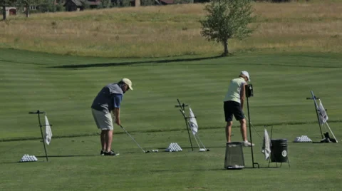Golfers practice at a golf course driving range in Idaho Stock Footage 36303925