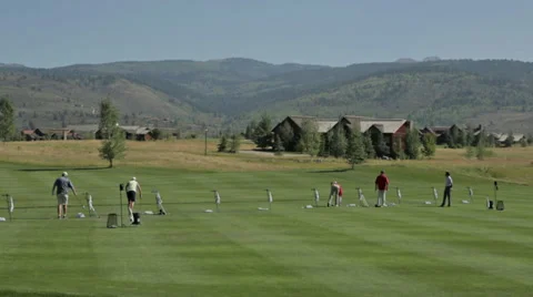 Golfers practice at a golf course driving range in Idaho Stock Footage 36303989