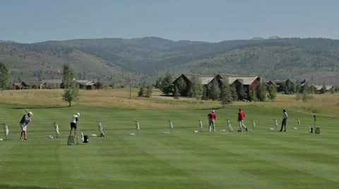 Golfers practice at a golf course driving range in Idaho Stock Footage 36304095