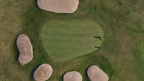Golfers practice their swing on a lush green course surrounded by sand bunkers Stock Footage 286222261