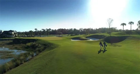 Golfers Walking Across Green, Golf Course, Aerial Drone Stock Footage