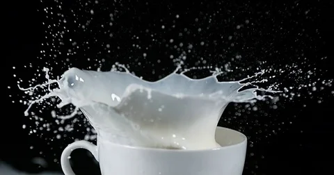 Golf's Ball in a Bowl with Exploding Milk against Black Background, slow motion Stock Footage 75969509