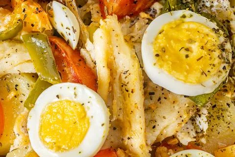 Gomes de sa codfish roasted in olive oil with tomatoes, peppers, onions, bo.. Foto stock