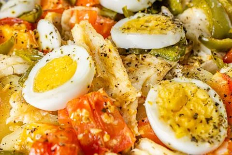 Gomes de sa codfish roasted in olive oil with tomatoes, peppers, onions, bo.. Stock Photos