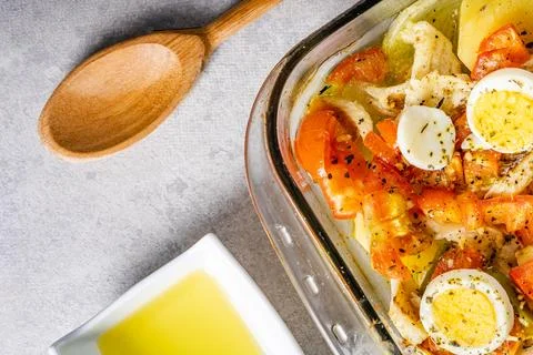 Gomes de sa codfish roasted in olive oil with tomatoes, peppers, onions, bo.. Foto stock