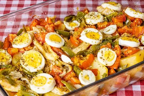 Gomes de sa codfish roasted in olive oil with tomatoes, peppers, onions, bo.. Stock Photos