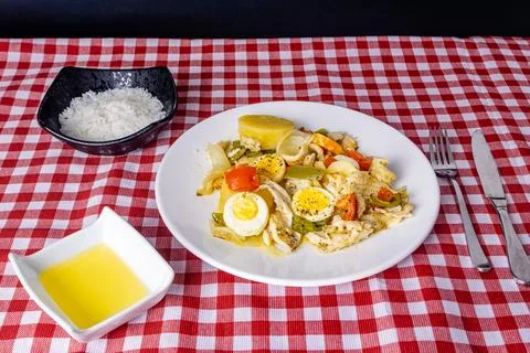 Gomes de sa codfish roasted in olive oil with tomatoes, peppers, onions, bo.. Stock Photos