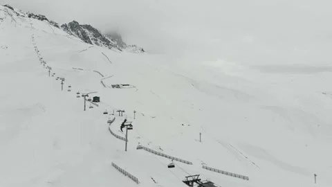 Gondola type cable car and skiers on snow covered slope of ski resort. Video stock 237820713