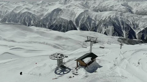 Gondola type cable car and skiers on snow covered slope of ski resort. Stockbeeldmateriaal 237821900