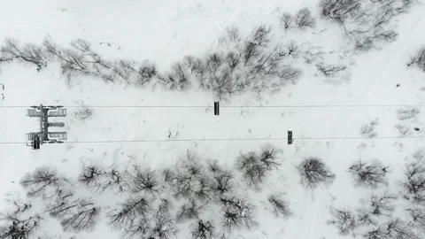 Gondola type cable car and skiers on snow covered slope of ski resort. Видео 237822708