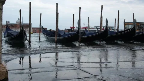 Gondolas bobbing in waves during acqua alta water rise, Venice lagoon, Italy Vidéo 332305430