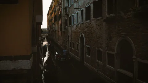 The gondolas floating through a narrow channel in Venice in the evening Stock Footage 97387105
