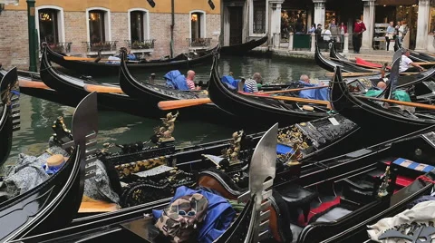 Gondolas parked as their passengers visit stores along the canal - Venice, Italy Stock Footage 48977310