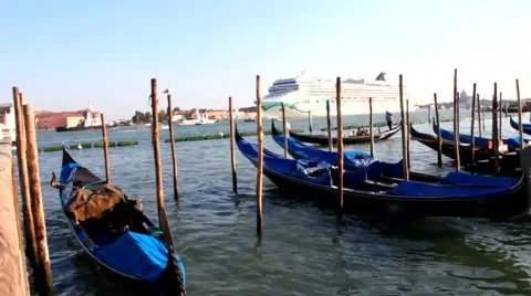 Gondolas at rest by Piazza San Marco and cruise ship coming into the open sea Stock Footage 43018229