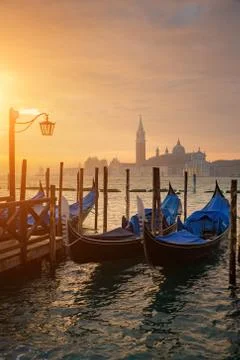Gondolas by Saint Mark square during sunrise with San Giorgio di Maggiore chu Stock Photos