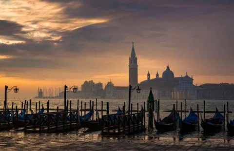 Gondolas by Saint Mark square during sunrise with San Giorgio di Maggiore chu Stock Photos