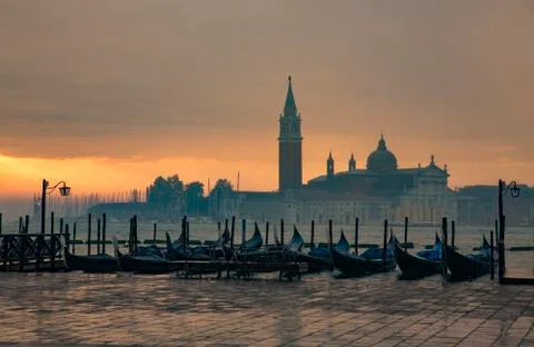 Gondolas by Saint Mark square during sunrise with San Giorgio di Maggiore chu Stock Photos