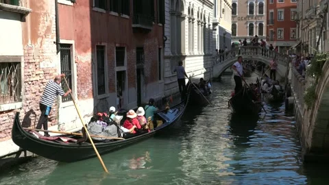 Gondolas with tourists float through the narrow streets among the old houses of Video stock 244388972