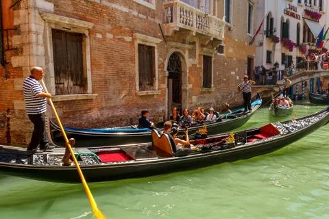 Gondolier with tourists at canal in venice, italy Stock Photos