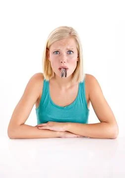 This is gonna be difficult to swallow. A young woman pulling a face with a fish Stock Photos