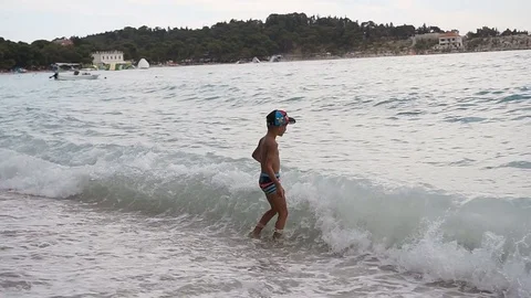 A good boy standing on the beach of the Adriatic Sea and joyfully escaping from Stock Footage 80390033