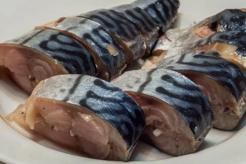Good cold fish appetizer. sliced a tasty marinated mackerel on a plate. close Stock Photos
