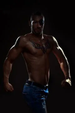 Good developed man with eye patch and tattoo posing in studio Stock Photos