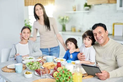 Good food makes your day. Hispanic family smiling at camera while enjoying a Stock Photos