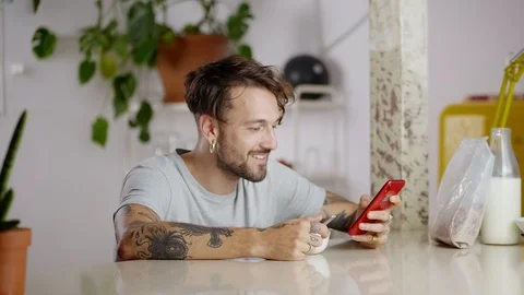 Good Hispanic male receiving message in modern application in smartphone at Video stock 108798534