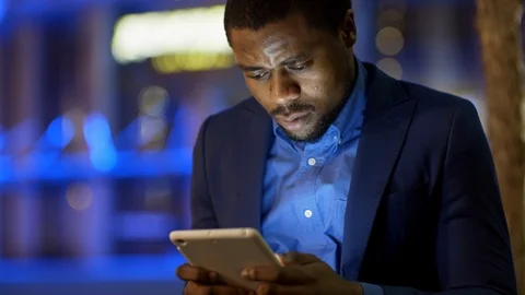 Good-looking African Man Typing on Tablet Stock Footage 100068416