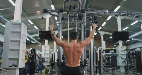 Good looking athletic guy exercises hard in a gym class concentrated working at Video stock 115937212