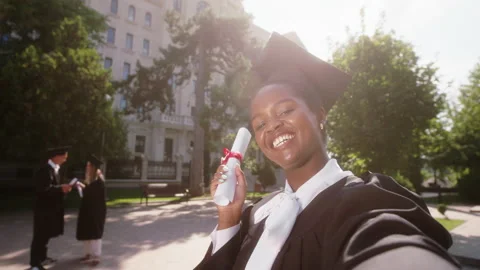 Good looking black lady student after the graduation in the college garden using Stock Footage 167095907