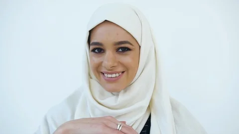 Good-looking cheerful young muslim woman in hijab holding in her hands small Stock Footage 122169140