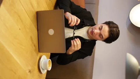 Good-looking concentrated modern young smart guy putting on his glasses Vidéo 259489668