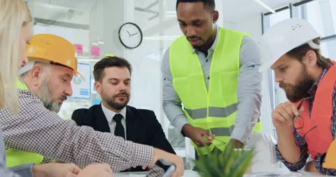 Good-looking confident professional black-skinned engineer explaining building Stock Footage 145608983