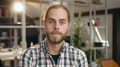 Good-looking confident young bearded guy standing in contemporary office room Stock Footage 133894099