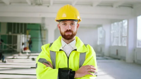 Good looking construction worker posing in front of the camera crossing hands he Stock Footage 170140343