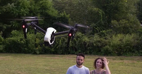 Good looking couple controlling a drone in the park. Stock Footage 80307336
