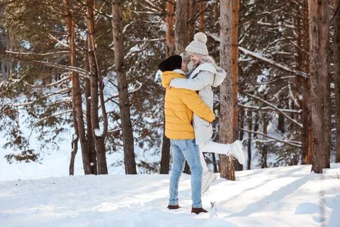 Good-looking couple is having fun in winter forest, spending Christmas holidays Stock Photos