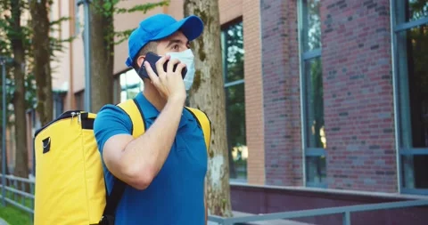 Good-looking delivery man with backpack going near modern office buildings Stock Footage 140114339