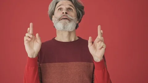 Good-looking elderly bearded man staying in prayer pose and crossing his fingers Stock Footage 120783252