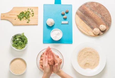Good-looking female hands while preparing delicious traditional italian meatb Stock Photos
