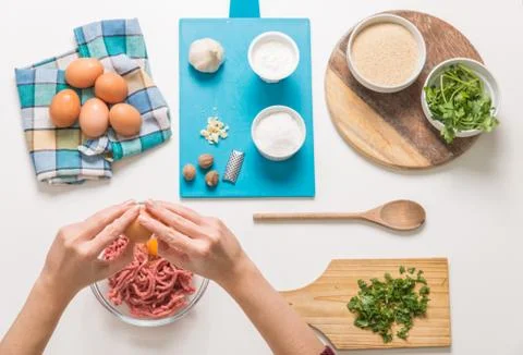 Good-looking female hands while preparing delicious traditional italian meatb Stock Photos