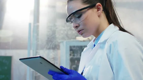 Good looking female scientist analyzing the results of experiment from the test Stock Footage 159812255