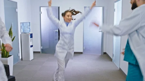 Good looking group of doctors and nurses dancing in front of the camera in a Stock Footage 129902835